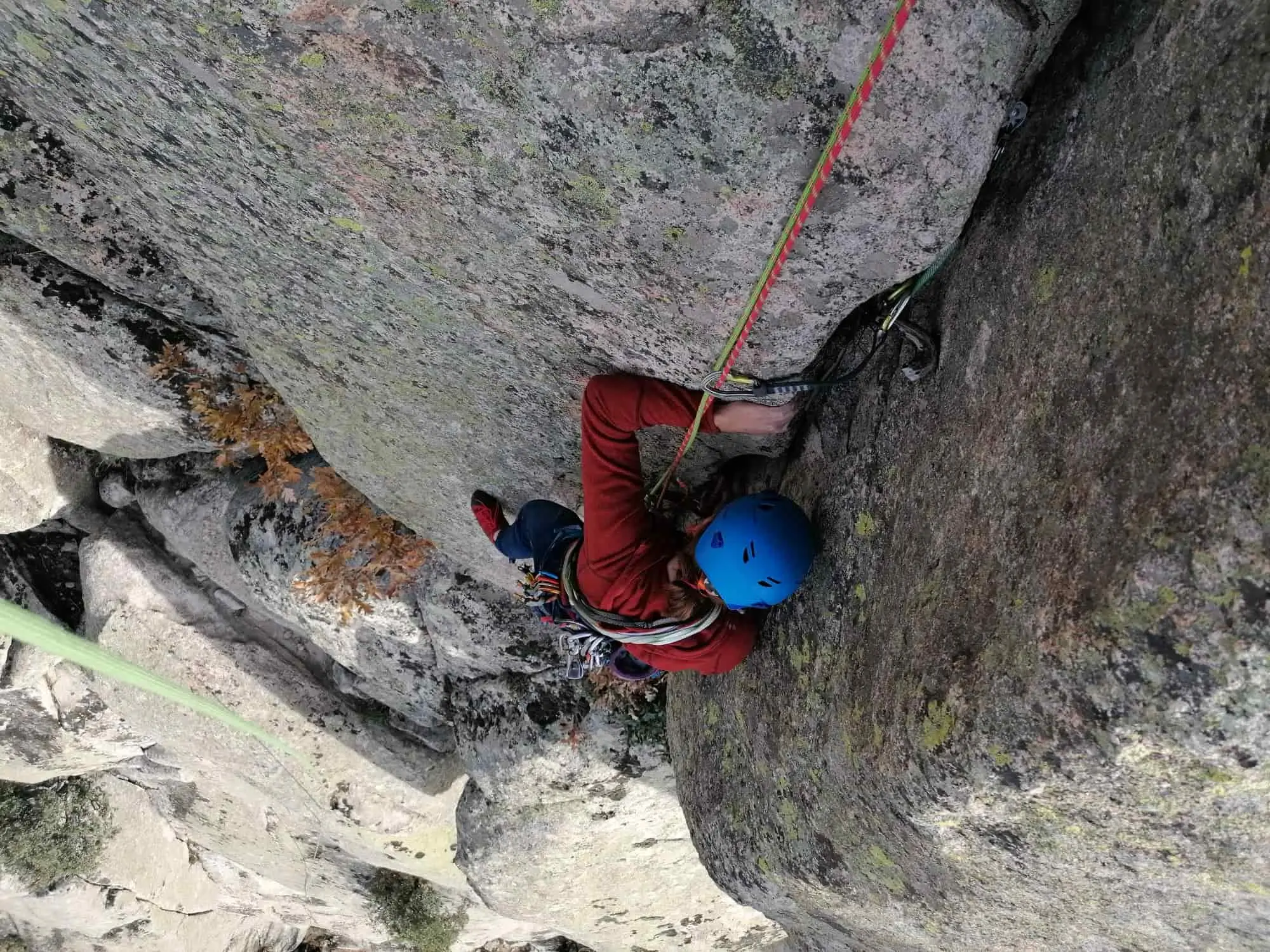 una escaladora realizando el curso de escalada clasica en vias semiequipadas de la escuela madrileña de alta montaña de la federacion de montañismo